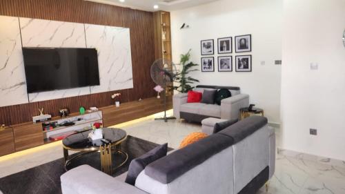 a living room with a couch and a flat screen tv at MM Luxury 3 bedroom Duplex Terrance in Aja