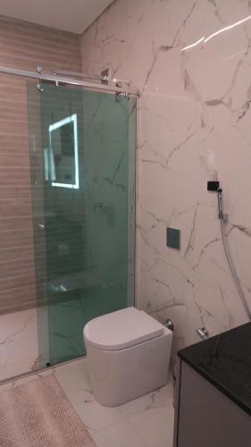 a bathroom with a toilet and a glass shower at Loft Jeri Premium in Jericoacoara