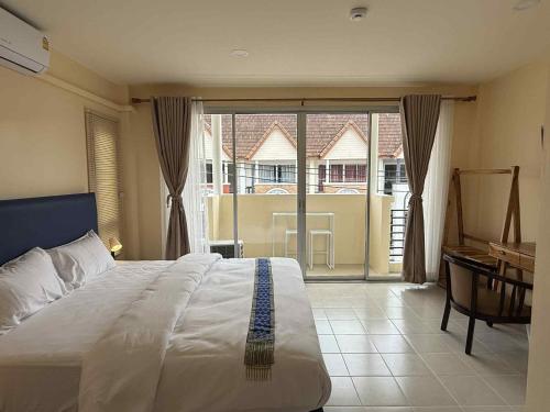 a bedroom with a bed and a large window at Kata Kata Stay in Kata Beach