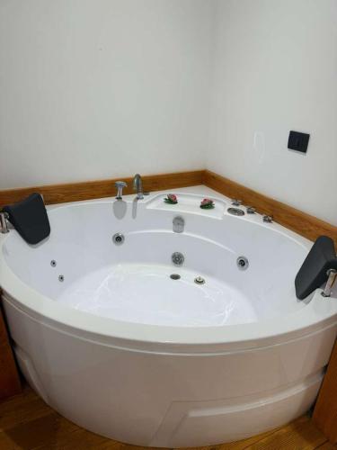 a white bath tub sitting in a room at You & Me Suite in Shkodër