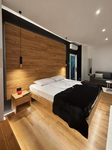a bedroom with a large bed with a wooden wall at You & Me Suite in Shkodër