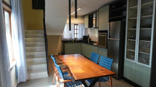 a kitchen with a wooden table and blue chairs at Loft Jeri Premium in Jericoacoara