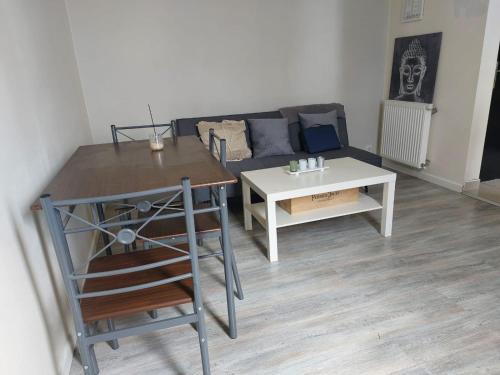 una sala de estar con un sofá y una mesa en Le Shelby's - Appartement cosy et lumineux !, en Villeneuve-Saint-Georges
