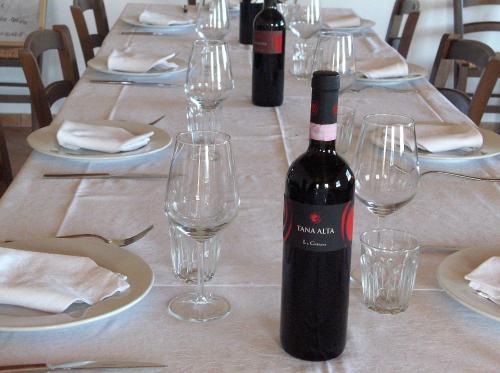a bottle of wine sitting on a table with glasses at B&B La Gibiana in Costigliole dʼAsti
