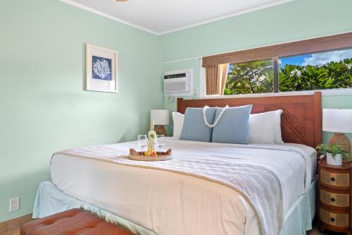 a bedroom with a large bed with a window at Kuleana 321 · KU 321 Spectacular Ocean Views in Kahana