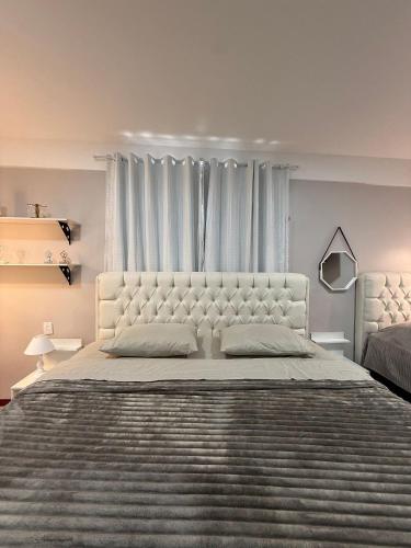 a white bedroom with a large bed and a window at STUDIO 201 | WIFI 600MB | RESIDENCIAL JC, um lugar para ficar. in Belém