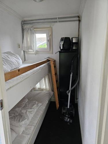 a small room with two bunk beds and a window at Chalet 36 in Giethoorn