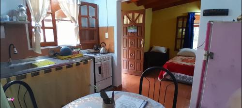 a kitchen with a sink and a stove top oven at Hospedaje Los Buenos Aires in Santa Ana