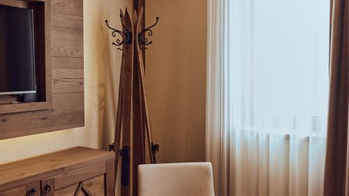 a room with a chair and a television and a curtain at Grey Family Hotel in Kopaonik