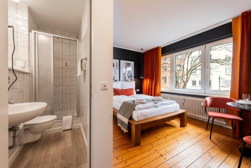 a bedroom with a bed and a bathroom with a sink at Klassen Stay - Design Apartments direkt am HBF Aachen in Aachen