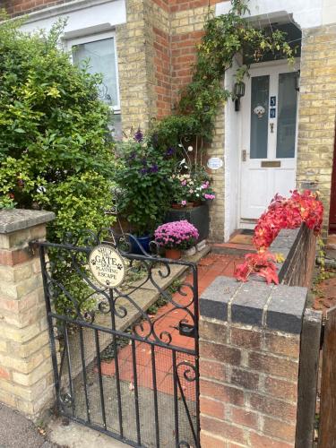 a front door of a house with a gate and flowers at Arts&BichonsB&B in Oxford