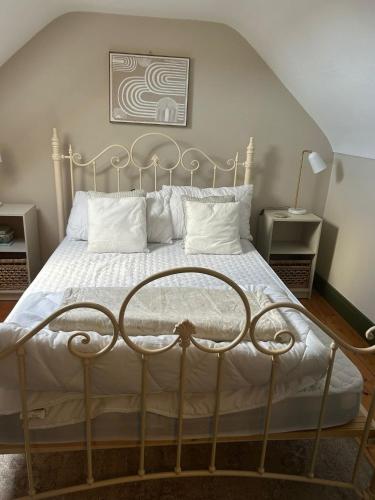 a bedroom with a bed with white sheets and pillows at The WEE HOUS Cresslough in Creeslough