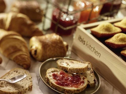 クルブヴォアにあるibis Paris la Défense Esplanadeのパンが置かれたテーブルの上にジャムを塗ったトーストの皿
