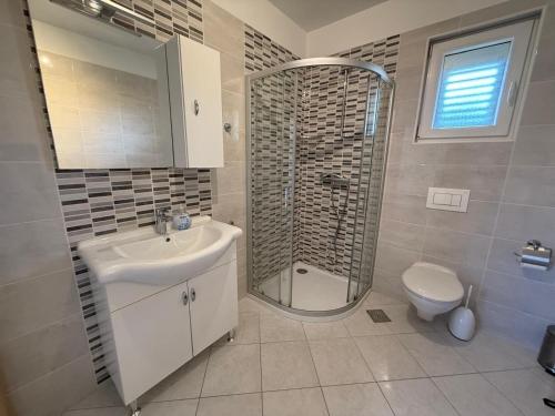 a bathroom with a shower and a sink and a toilet at Ferienhaus FILI Insel Murter mit privaten Pool und großer Terrasse in Murter