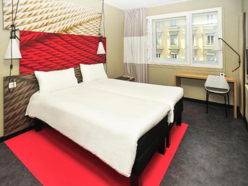 a bedroom with a large bed with a red headboard at ibis Lyon Centre in Lyon