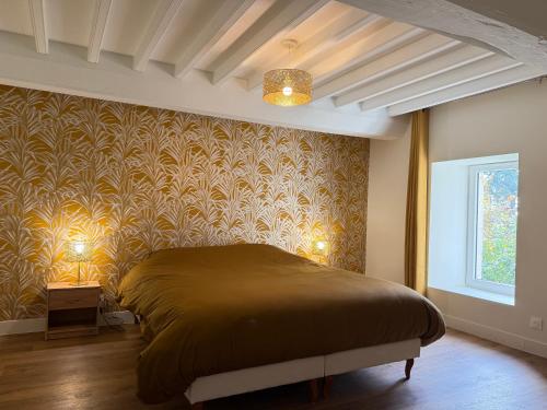 a bedroom with a large bed and a window at Le Mesnil in Bayeux
