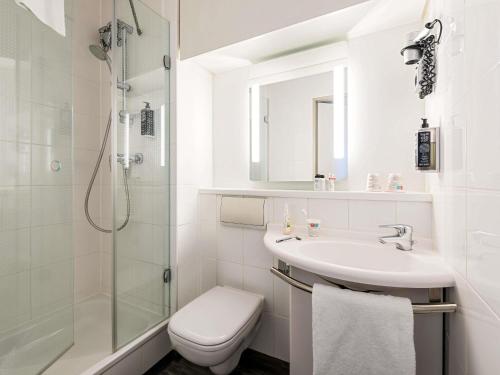 a bathroom with a sink and a toilet and a shower at ibis Hotel Regensburg City in Regensburg
