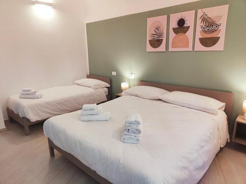 two beds in a room with towels on them at Casa Nanni in Genova