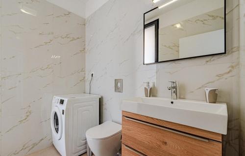 une salle de bain avec un lavabo, des toilettes et un miroir dans l'établissement Villa Evia by Villas Guide, à Prižba