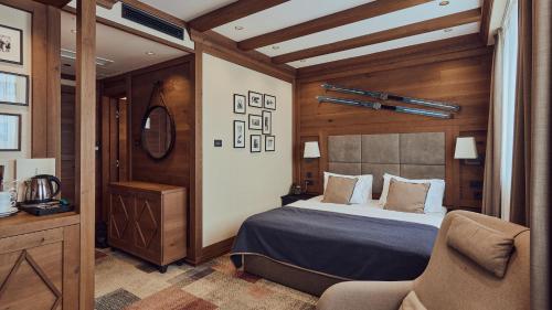 a bedroom with a bed and a chair in a room at Grey Family Hotel in Kopaonik