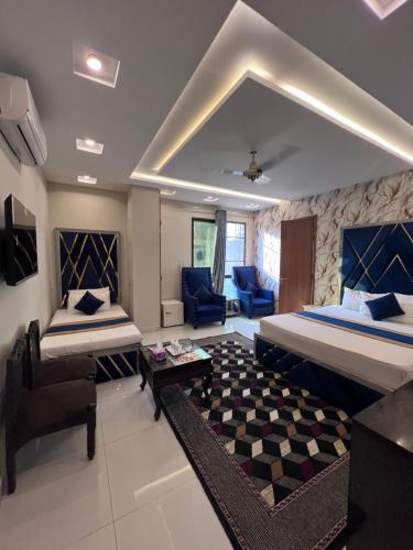 a bedroom with two beds and a living room at Park View Hotel Gulberg in Lahore