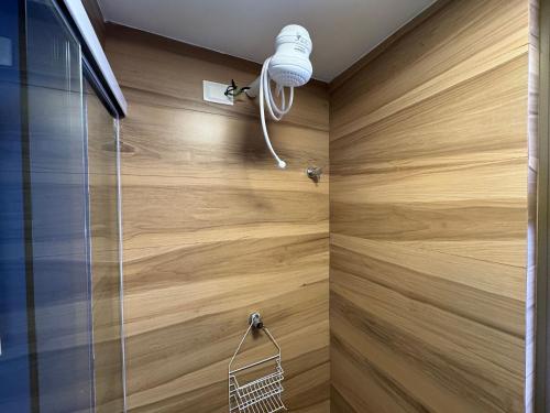 a shower with wooden walls and a glass door at Beira-mar do Cabo Branco com varanda UN113 in Penha