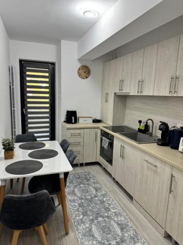 a kitchen with wooden cabinets and a table and chairs at A B V Central Apartament in Râmnicu Vâlcea