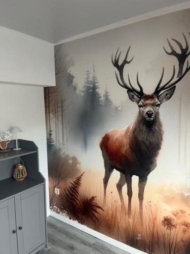 a painting of a deer on a wall in a room at Le refuge du Cerf in Bouillon