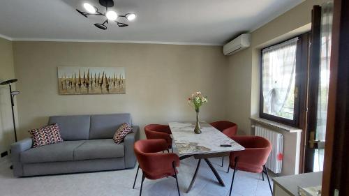 a living room with a couch and a table with chairs at A casa di Gina in Airasca