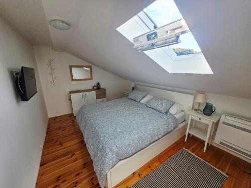 a small bedroom with a bed and a skylight at Kuća za odmor Brlog in Brlog