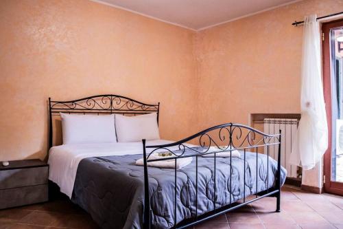 a bedroom with a bed in a room with a window at Trilocale con Piscina Roma in Colonna