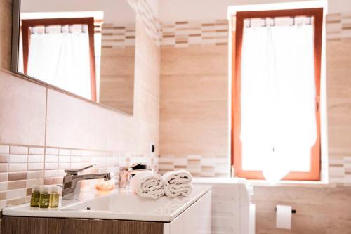 a white bathroom with a sink and a mirror at Trilocale con Piscina Roma in Colonna