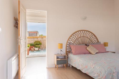a bedroom with a bed and an open door at Central Narbonne with rooftop terrace in Narbonne