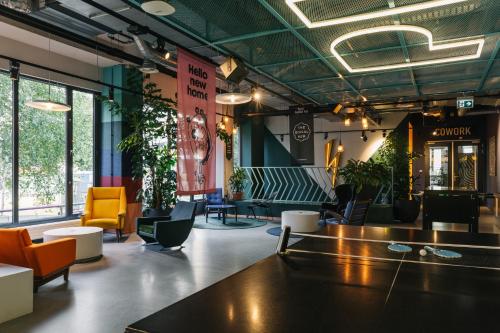 a lobby with chairs and tables in a building at The Social Hub Amsterdam West in Amsterdam