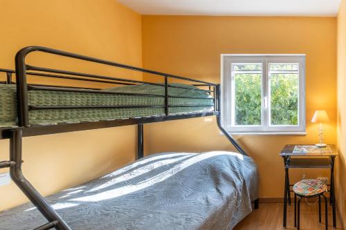 ein Schlafzimmer mit zwei Etagenbetten und einem Fenster in der Unterkunft Appartement N°2 - Piscine Partagée in Lagorce