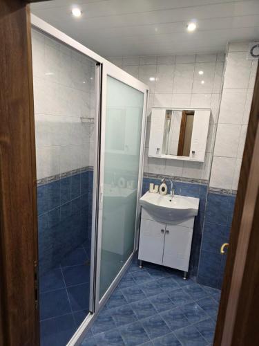 a bathroom with a shower and a sink and a mirror at Апартаменти Ванкови 2 in Veliko Tŭrnovo