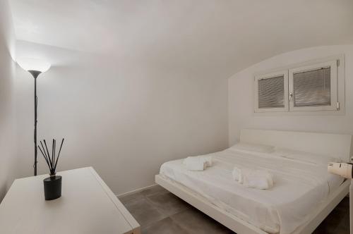 a white bedroom with a bed and a table at La casina di Camilla in Florence