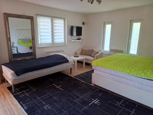 1 dormitorio con cama, espejo y sofá en Sarajevo Holiday Apartments 1, en Sarajevo