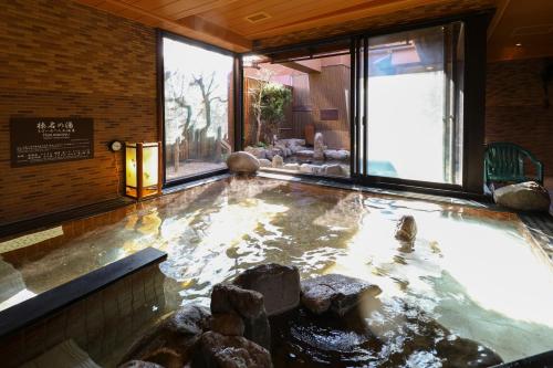 ein großes Wasserbecken mit Steinen in einem Raum in der Unterkunft Dormy Inn Takasaki in Takasaki