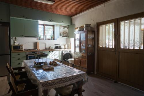 une cuisine avec une table et une cuisine avec une cuisinière dans l'établissement Omodos Serenity House, à Omodos