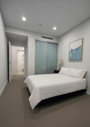 - une chambre avec un grand lit blanc dans l'établissement Cozy Suite in Schofields, à Schofields