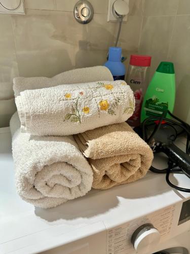 a pile of towels sitting on top of a bathroom counter at Vidolux Studio - Free Garage and Fast WiFi in Niš