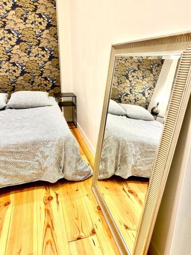 einen Spiegel vor einem Bett im Schlafzimmer in der Unterkunft Le Havre Coty proche plage Hyper centre in Le Havre
