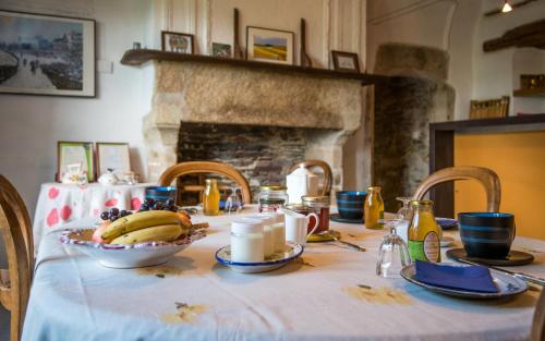 een tafel met een tafelkleed met een kom bananen bij Le Prieuré de Saint Sauveur - Climatisation - Séjour Nature & Détente in Comps-la-Grand-Ville