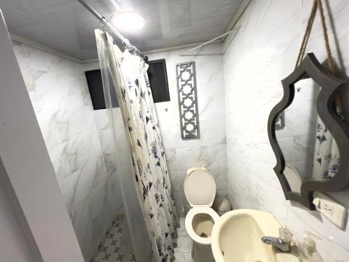 un baño con inodoro y lavabo en Como en casa apartment, en Cali