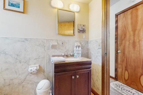a bathroom with a sink and a toilet and a mirror at Seascape in Folly Beach