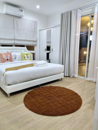a bedroom with a large bed and a rug at Litha Homestay HatYai in Sathani Khlong Rian