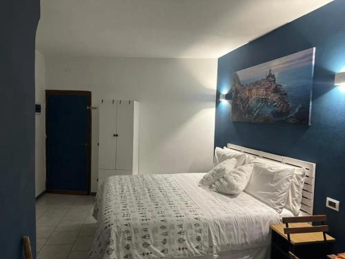 a bedroom with a white bed with a blue wall at Ca Du Grifun 2 in Vernazza