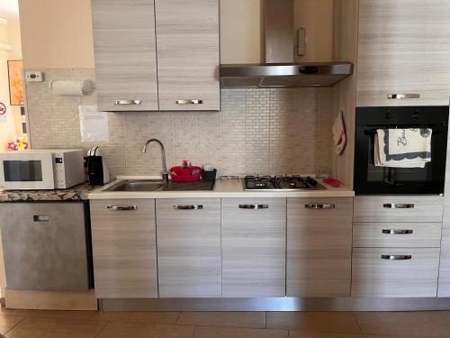 a kitchen with a sink and a stove top oven at Casa Vacanze DEFUK in Montefiascone