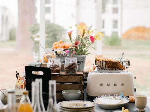 a table topped with plates and bowls of food at Hotel Mercure Parc du Coudray - Barbizon in Le Coudray-Montceaux